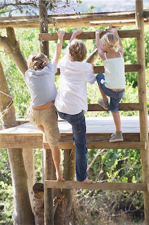 simsearch:6108-05872670,k - Rear view of children climbing ladders to tree house Foto de stock - Royalty Free Premium, Número: 6108-05872657