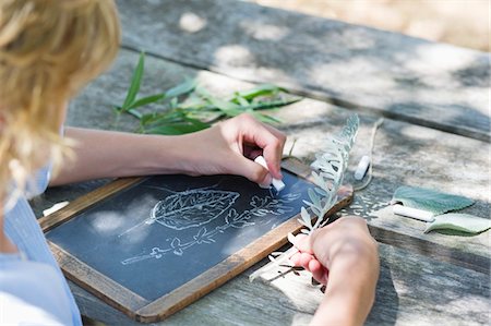 simsearch:6108-06907699,k - Side profile of a little boy making drawing of leaves on slate outdoors Foto de stock - Sin royalties Premium, Código: 6108-05872659