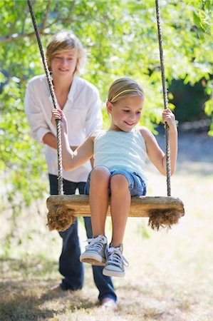 Smiling little siblings playing in tree swing Stock Photo - Premium Royalty-Free, Code: 6108-05872666