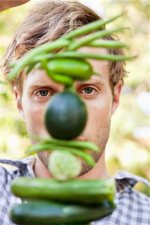 Young man holding vegetables Stock Photo - Premium Royalty-Free, Code: 6108-05872616