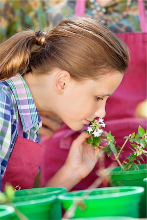 simsearch:6108-05869639,k - Girl smelling a flower in a garden Stock Photo - Premium Royalty-Free, Code: 6108-05872639