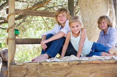 Portrait of children sitting in tree house Foto de stock - Sin royalties Premium, Código: 6108-05872727