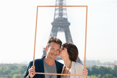 paris lovers eiffel - Couple framing their dream vacation with Eiffel Tower in the background, Paris, Ile-de-France, France Stock Photo - Premium Royalty-Free, Code: 6108-05872944