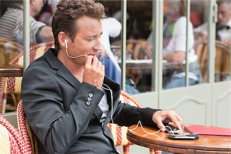 Man talking on a mobile phone in a restaurant, Paris, Ile-de-France, France Stock Photo - Premium Royalty-Free, Code: 6108-05872915