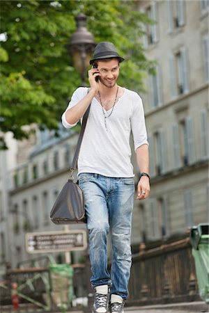 L'homme marche sur la route et de parler sur un téléphone mobile, Paris, Ile-de-France, France Photographie de stock - Premium Libres de Droits, Code: 6108-05873042