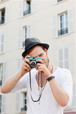 person holding a camera - Man taking a picture with a camera, Paris, Ile-de-France, France Stock Photo - Premium Royalty-Free, Code: 6108-05873046