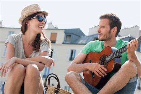 people sitting playing a guitar - Man playing a guitar with a woman smiling, Canal St Martin, Paris, Ile-de-France, France Stock Photo - Premium Royalty-Free, Code: 6108-05873061