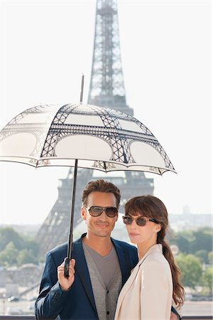 eiffel tower - Couple under an umbrella with the Eiffel Tower in the background, Paris, Ile-de-France, France Stock Photo - Premium Royalty-Free, Code: 6108-05873154