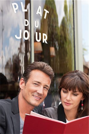 Couple reading menu at a restaurant, Paris, Ile-de-France, France Foto de stock - Sin royalties Premium, Código: 6108-05873161