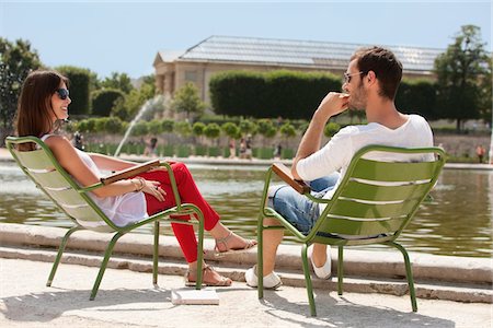 Couple sitting in chairs near a pond in a garden, Bassin octogonal, Jardin des Tuileries, Paris, Ile-de-France, France Stock Photo - Premium Royalty-Free, Code: 6108-05873260