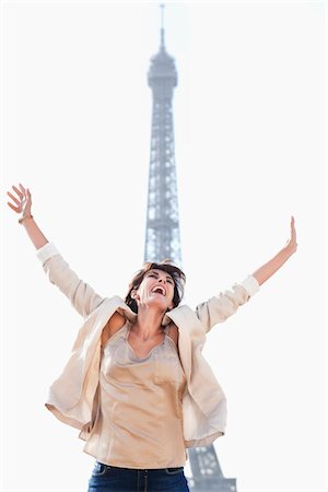 Woman shouting in excitement with the Eiffel Tower in the background, Paris, Ile-de-France, France Foto de stock - Sin royalties Premium, Código: 6108-05873273