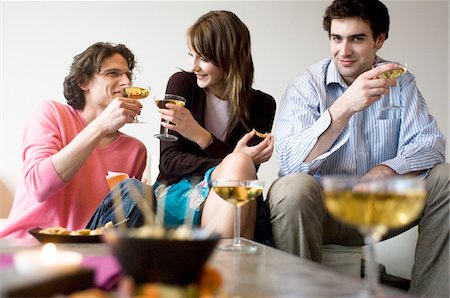 party in livingroom - Couple and man drinking champagne Foto de stock - Sin royalties Premium, Código: 6108-05873377