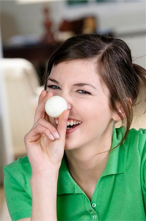 Young smiling woman covering her nose with hard boiled egg Foto de stock - Sin royalties Premium, Código: 6108-05873444