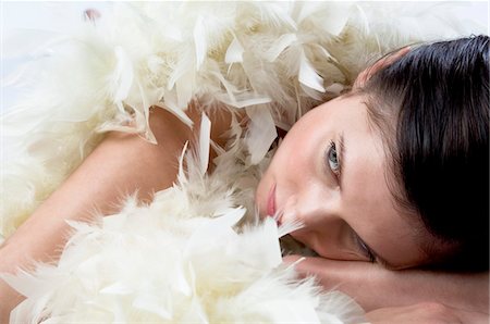 Young woman with white feather boa Stock Photo - Premium Royalty-Free, Code: 6108-05873412