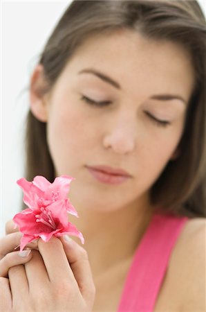 simsearch:6108-05873540,k - Young woman holding pink flower, closed eyes Stock Photo - Premium Royalty-Free, Code: 6108-05873438