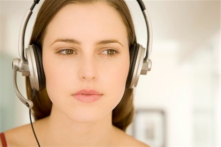Portrait of a young woman, listening to music with headphones Stock Photo - Premium Royalty-Free, Code: 6108-05873540