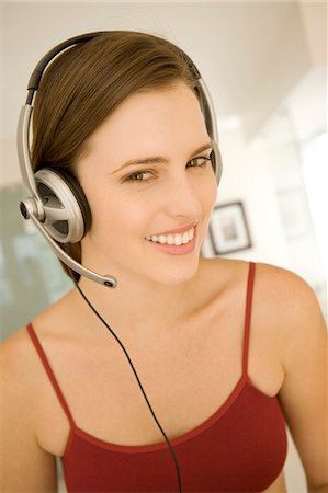 Portrait of a young woman, listening to music with headphones Stock Photo - Premium Royalty-Free, Code: 6108-05873542