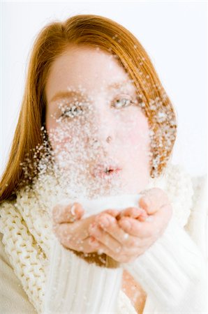 Close-up of a young woman blowing snow from her cupped hands Stock Photo - Premium Royalty-Free, Code: 6108-05873572