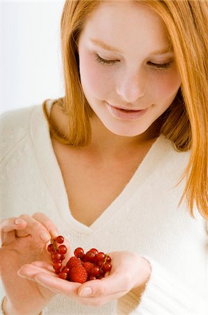 Close-up of a young woman holding berry fruits Stock Photo - Premium Royalty-Free, Code: 6108-05873601