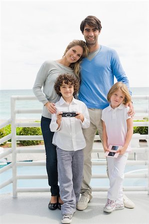 simsearch:6108-05858274,k - Couple with their children standing by a railing Stock Photo - Premium Royalty-Free, Code: 6108-05873982