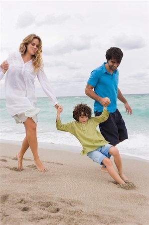 Couple playing with their son on the beach Foto de stock - Sin royalties Premium, Código: 6108-05873997