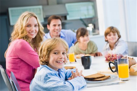 family meal kitchen - Portrait of a family having breakfast and smiling Stock Photo - Premium Royalty-Free, Code: 6108-05873908