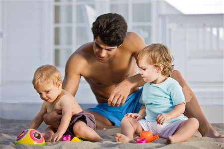 Man playing with his son and daughter in sand Stock Photo - Premium Royalty-Free, Code: 6108-05874039
