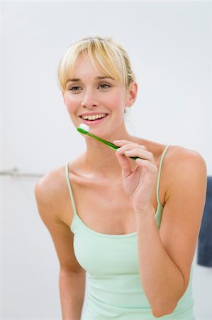 simsearch:6108-05856072,k - Woman holding a toothbrush Fotografie stock - Premium Royalty-Free, Codice: 6108-05874173