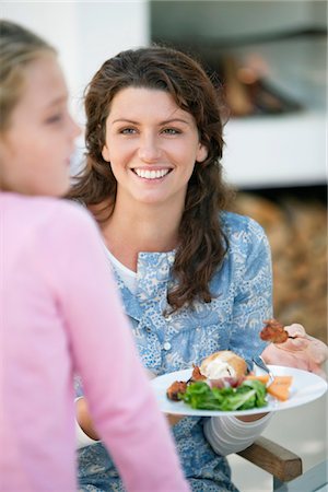 Woman holding a plate of kebab and smiling Stock Photo - Premium Royalty-Free, Code: 6108-05874286