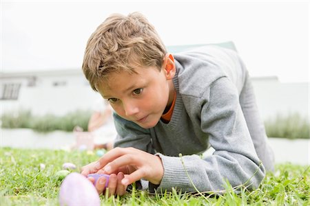 easter egg - Boy looking at an Easter egg Stock Photo - Premium Royalty-Free, Code: 6108-05874291