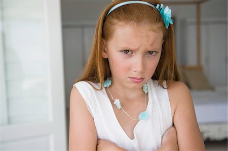 sulking arms folded - Portrait of a girl looking displeased Stock Photo - Premium Royalty-Free, Code: 6108-05874296