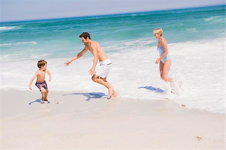 simsearch:6108-05865140,k - Famille jouant sur la plage Photographie de stock - Premium Libres de Droits, Code: 6108-05874366