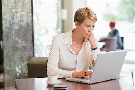 simsearch:6108-06166064,k - Businesswoman working on a laptop in a restaurant Foto de stock - Sin royalties Premium, Código: 6108-05874445