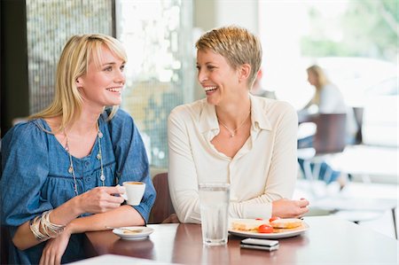 full cup - Two women sitting in a restaurant and smiling Stock Photo - Premium Royalty-Free, Code: 6108-05874449