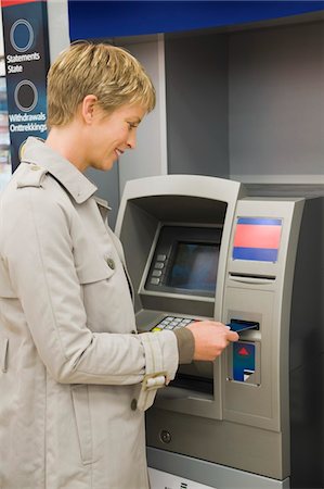 Woman inserting a credit card into ATM Foto de stock - Sin royalties Premium, Código: 6108-05874436