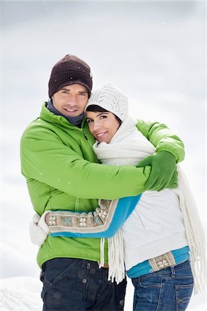 snow couple smiling hugging - Young couple embracing, smiling at camera Stock Photo - Premium Royalty-Free, Code: 6108-05874564
