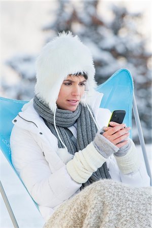 simsearch:6108-05874576,k - Young woman using mobile phone in snow Foto de stock - Royalty Free Premium, Número: 6108-05874571