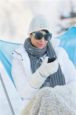 Jeune femme à l'écoute de MP3 player dans la neige Photographie de stock - Premium Libres de Droits, Code: 6108-05874577