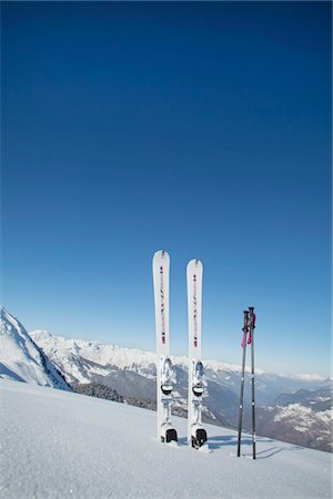 esporte de inverno - Skis and ski poles stuck in the snow Foto de stock - Royalty Free Premium, Número: 6108-05874594