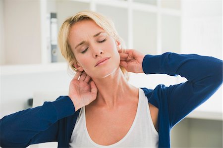 Woman touching her neck Stock Photo - Premium Royalty-Free, Code: 6108-05874502