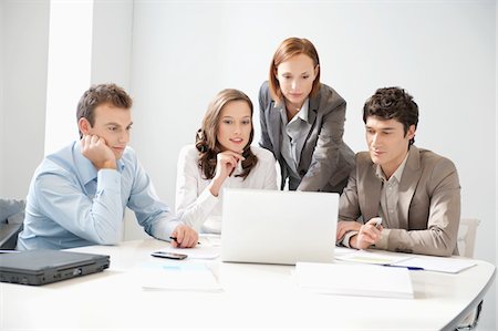 simsearch:6108-05868312,k - Business executives looking at a laptop in a board room Stock Photo - Premium Royalty-Free, Code: 6108-05874685