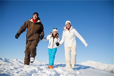 simsearch:6108-05867178,k - Couple and daughter in ski wear walking in snow Fotografie stock - Premium Royalty-Free, Codice: 6108-05874606