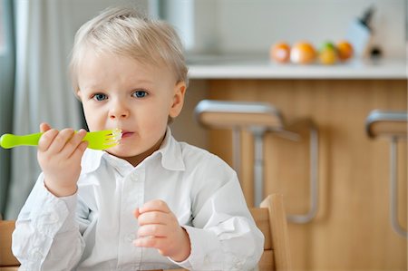 Portrait of a boy eating with a fork Stock Photo - Premium Royalty-Free, Code: 6108-05874612