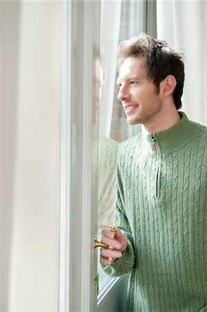 front door knob - Man looking out through a door glass Stock Photo - Premium Royalty-Free, Code: 6108-05874628