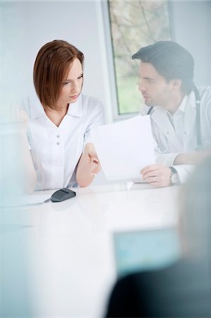 doctors office - Doctors discussing a medical report Foto de stock - Sin royalties Premium, Código: 6108-05874763