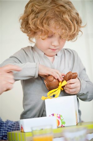 Boy opening his birthday present Stock Photo - Premium Royalty-Free, Code: 6108-05874760