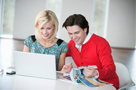 Couple à l'aide d'un ordinateur portable et souriant Photographie de stock - Premium Libres de Droits, Code: 6108-05874771