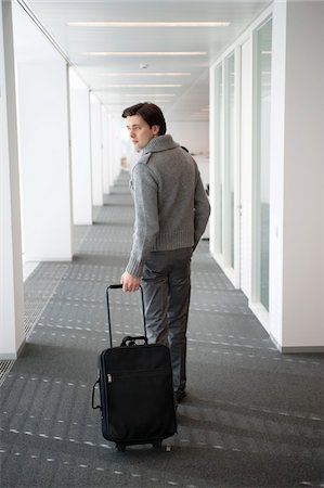 Businessman carrying his luggage Stock Photo - Premium Royalty-Free, Code: 6108-05874777