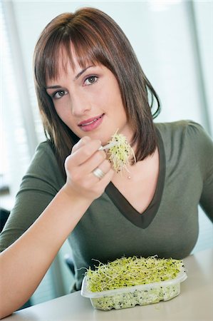 Businesswoman eating bean sprouts Stock Photo - Premium Royalty-Free, Code: 6108-05874786