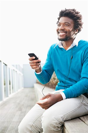 simsearch:6108-08725387,k - Man listening to an MP3 player Stock Photo - Premium Royalty-Free, Code: 6108-05874705